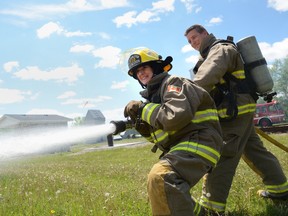 Lynn Doyle sprays a fire hose – with a little help from firefigher Adam Fournier – Saturday afternoon. 
EMILY MOUNTNEY/TRENTONIAN/QMI AGENCY