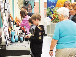 Art lovers look over the pieces made by art students at Sacred Heart School, and later sold with profits going to Neighbourhood Outreach Wetaskiwin.