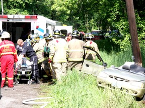 Emergency personnel work on a man extricated from a vehicle following an incident on County Road 4, north of Picton Wednesday morning.