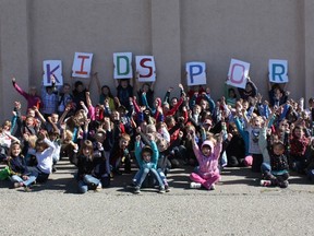 Children post in front of a school in support of KidSport Canada. (Photo: KidSport Alberta)