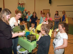 Back for seconds. Ste Marguerite Bourgeoys School Grade 3 teacher Kaitliin Bryck (left) and parent volunteer Lana Wyder serve up Sweet Green Monster Smoothies at Family Fun Night in the school gymnasium, Tuesday evening. The nutritional beverage of blended pineapple, dates, spinach and bananas complemented the Healthy Living Healthy Choices theme of the event.