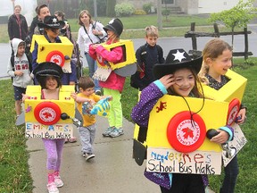 Emma Tadeu, front left, Madeline Blais, centre, and Jordyn Watson lead the way as the walking school bus makes its way to Cataraqui Woods Elementary School Wednesday morning.
Michael Lea The Whig-Standard