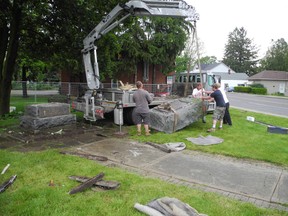 A team from Nelson Stone Centre removes the main monument and base blocks from the St. George Cenotaph on Wednesday. They will be refurbished and reinstalled in time for Canada Day celebrations. (MICHAEL-ALLAN MARION, The Expositor)