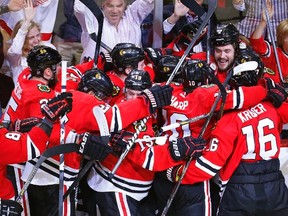 Chicago Blackhawks defenceman Brent Seabrook (top R) is mobbed by teammates after scoring in overtime to defeat the Detroit Red Wings and win Game 7 of their NHL Western Conference semifinal hockey playoff in Chicago, Illinois May 29, 2013. (REUTERS)