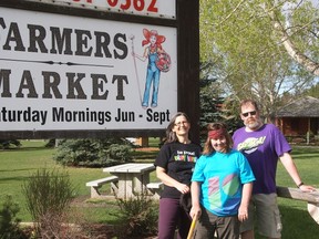 Valerie McCracken, Daniel Theis and Tim Geise were getting things in order for the Farmers’ Market on Sunday. The market begins its 18-week season Saturday.