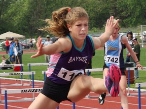 Bayside Red Devils' Katherine Herron clears a hurdle during the COSSA track and field championships last Thursday at Belleville's M.A. Sills Park. Herron placed fourth in the midget women's 300m hurdles, but was also a double gold medallist, winning the 100m and setting a new COSSA record in the winning the triple jump.