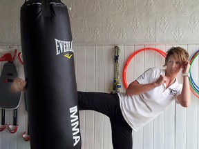 Twilight Fitness owner Christina Outingdyke-Ellis shows off her muay thai skills at the Grand Opening.