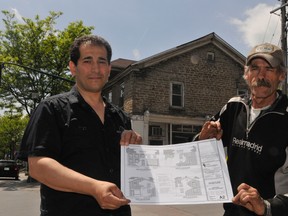 Sam Rawas, left, and his employee Murray White hold up drawings of the planned redesign of Brockville's oldest stone structure, pictured in the background. The group Heritage Brockville is assisting with advice on the renovation. RONALD ZAJAC The Recorder and Times