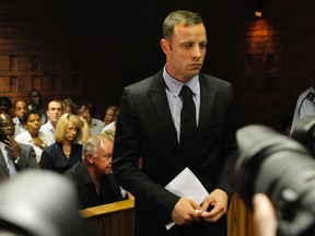 Oscar Pistorius stands in the dock during a break in court proceedings at the Pretoria Magistrates court, February 20, 2013. Pistorius was applying for bail after being charged with shooting dead his girlfriend, 30-year-old model Reeva Steenkamp, in his Pretoria house. (REUTERS/Siphiwe Sibeko)