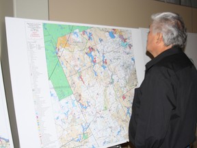 Cliff Meness, a negotiating representative with the Algonquin land claim, looks at one of the maps on display before a meeting with municipal and area politicians, Friday, May 31, 2013, at the Davedi Club in North Bay.