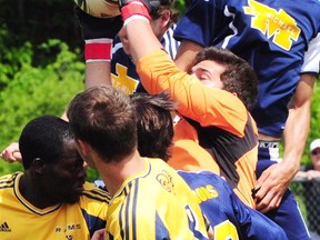 St. Joseph's goalkeeper Zach Moniiz gets crushed in a crowd as he makes the play Friday against the St. Michael Warriors in the WOSSAA AA soccer final. Moniz went down with an ankle injury 18 minutes into the second half and did not return. St. Michael won 1-0 on penalty kicks. (R. MARK BUTTERWICK, St. Thomas Times-Journal)