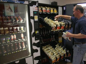 Terry MacMillan, of MacMillan Vending, restocks a snack machine at Chippewa Secondary School, Friday, May 31, 2013. His company owns and services vending machines at all secondary schools in the Near North District School Board, while the Dairy Farmers of Canada and Coke also own machines.
