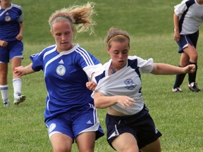 St. Chris Cyclones captain Maria Mitchell, left, gets away with a tug on the jersey of  Cardinal Carter Cougar Cristina Pearce in the SWOSSAA "AA" senior girls soccer challenge games Friday, May 31, 2013 at St. Chris in Sarnia, Ont. (PAUL OWEN, The Observer)