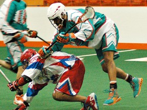 Defender Billy Dee Smith of Six Nations knocks down Peterborough's Shawn Evans during Major Series Lacrosse action Sunday at the ILA. (DARRYL G. SMART, The Expositor)