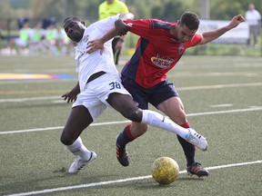 Kingston FC player Guillaume Surot defends against Niagara United player Preston Corporal during a match in Kingston Saturday. (DANIELLE VANDENBRINK The Whig-Standard)