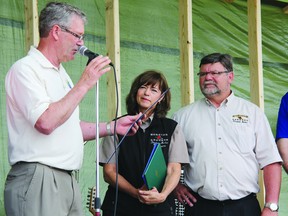 Deputy Mayor Tom Mohns, left, reads from a plaque congratulating  Debbie and Denis Moncion who have owned and operated Moncion Grocers - Petawawa Market for the last 30 years, during anniversary celebrations held Saturday. For more community photos, please visit our website photo gallery at www.thedailyobserver.ca.