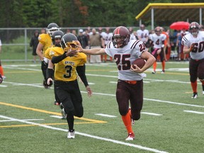 Wild running back Nick Weiszhaar (25) throws a straight-arm at Knight defensive back Nicholas Mahon (3) on his way to scoring the team's first touchdown in Ontario Football Conference action Saturday at Omischl Sports Complex.