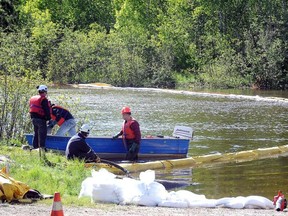 File photo Gino Donato/The Sudbury Star/QMI Agency
Crews work at the Wahnapitae River to prevent environmental damage from oil spills, following a train derailment in Wanup.