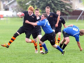 Warrior Madison Radersma tries to get around Titan Justin Mayne during the Peace High School Rugby championship Friday at Macklin Field. Grande Prairie Composite High Warriors took the Friday with a 31-17 win over the Peace Wapiti Academy Titans. (Diana Rinne/Daily Herald-Tribune)