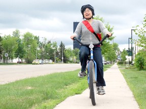 Jocelyn Turner/Daily Herald-Tribune
Andrea Rode rides her bike along 102 Street while on her way to volunteer at Peace Wapiti Academy for its burger binge event Monday. Rode thought she’d bike instead of using her vehicle in honour of the Commuter Challenge taking place all week long.