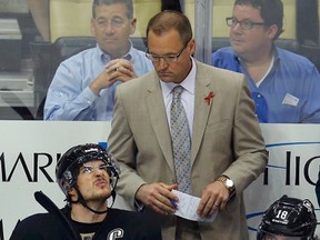 Pittsburgh Penguins center Sidney Crosby (87) looks up at the score clock as he sits on the bench next to James Neal (18) and head coach Dan Bylsma during the final minutes of their loss to the Boston Bruins in Game 2 of their NHL Eastern Conference finals hockey playoff series in Pittsburgh, Pennsylvania, June 3, 2013. (REUTERS/Brian Snyder)