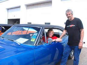 Barb and Dave Wheeler had their cars shined up for the Dutton Auto Show at Dave Wheeler Auto last week in Dutton. Behind the wheel of the '69 Dodge Coronet Super Bee is Barb Wheeler.