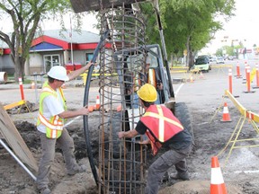 Crews prepare the bases of new traffic lights into palce at the ointersection of Crawford Avenue and Main Street in Melfort. The new lights and wheelchair ramps are expected to be in place by the end of June.