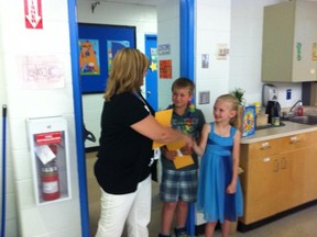 Luke Brown and Cheyanne Osmond, both in grade three, thank a community guest for attending Father Beauregard School’s Leadership Day. Student greeters lined the hallways before the presentation in the school’s gym. Photo Andrew Bates/Today staff