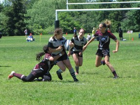 Neela MacLeod-Farley of the St. Mary's Mustangs tries to escape the clutches of Annie Nuygen of Niagara Falls' Saint Michael's Mustangs in the St. Mary’s 14-12 win Tuesday in the teams’ consolation quarterfinal match.