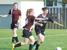 Knights’ Kristina Richer (14) battles St. Basil’s Mikayla Ferlaino for the ball as teammate Stephanie  Cain looks on during the city final last week.