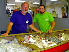 Steve and Mike Sharpe stand behind a canoe filled up with ice cold refreshments for their 50th anniversary party June 1.