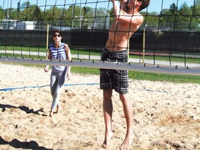 Michael McCaffrey jumps up to hit the volleyball over the net as partner Kaila Chekosky looks on. The co-ed twos team will compete in the KMTS Co-ed 2’s Volleyball Tournament on Saturday, June 8 as the beach volleyball season starts up in Kenora.