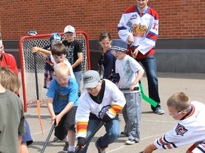 Oil Kings player and former VES student Brandon Baddock plays street hockey with some students.