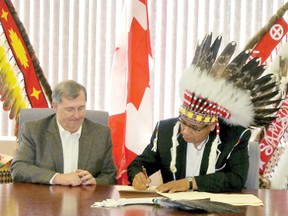 Chief Marvin Yellowbird, right, signs an agreement with ATCO Pipelines for the replacement  of a pipeline running through the First Nation ,May 30.