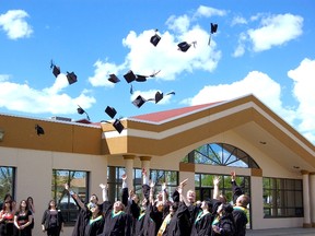 St. Thomas More Catholic School graduates throw their caps into the air following the graduation ceremony on June 1. (Daniele Alcinii/Fairview Post)