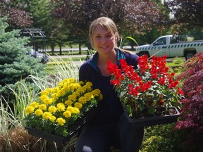 Assistant supervisor of horticulture Reta Horan shows off trays of annuals that will be planted around the gazebo at Southside Park. HEATHER RIVERS/WOODSTOCK SENTINEL-REVIEW
