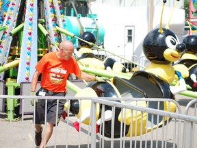 Worker Lance Desbien inspects the bumble bee ride at the 42nd annual St. Anne's Community Festival which kicked off Wednesday afternoon. (Times-Journal)