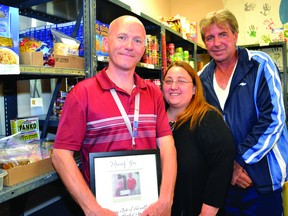 Bonnie Gommert, executive director of Food For All Food Bank, stands with Garry Young's family members, Art Hitsman, left, and Randy Miller. (LESLIE WALKER/THE RECORDER AND TIMES)