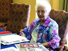 Beatrice Bodell, 87, looks over photos of her family while recounting her life in Strathcona County. Leah Germain/Sherwood Park News/QMI Agency