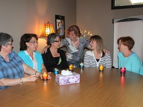 Members of the Suicide Prevention Support Group gather around lit candles at their meeting Wednesday at the Suicide Prevention Resource Centre. Members Rhonda Laviolette (from left), Sandy Krahn, Brenda Pelletier, Vivian Anderson, Diedre Crocker and Tammy Ouellette have each lit a candle in honour of a loved one they have lost to suicide. (Jocelyn Turner/Daily Herald-Tribune)