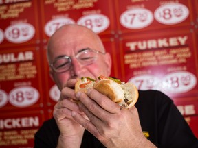 Hoagie House owner Phil Thompson digs into the Division Street  establishment's famous philly cheesesteak. The Hoagie House offers 11 different kinds of hoagies. (SAM KOEBRICH For the Whig-Standard)