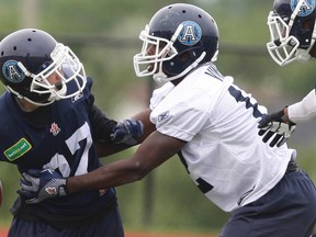 Defensive back hopeful Brent Vinson puts the grab on receiver Quincy Hurst during Thursday’s Argonauts practice. (Veronica Henri, Toronto Sun)