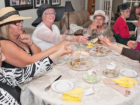 Wearing the required fancy hats or fascinators, royal baby shower attendees Rosemary Prohaska (left), Sharon Wilson, Sandy Paul, Gayann Chowhan and Anne Porr raise their glasses to toast Prince William and Kate Middleton on Thursday.  Rita Mustard hosted the shower at her Brantford home, with baby gifts being donated to the local Pregnancy Resource Centre in Brantford.(BRIAN THOMPSON, The Expositor)