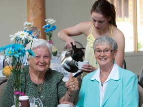 Marie Mason gives the thumbs up for another successful Seniors Tea, June. Madison Grainger, of Cochrane High School, serves tea to Marie and Bonnie Baynes during the sold out event at the Cochrane RancheHouse.