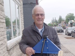 Retired teacher and Southampton resident Bob Hastings holds up his invention- the All Weather Bin Caddy, which is now sold at Home Hardware.