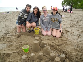 Students from Brantford made the most of “beach day” despite the cool weather on Friday, June 7, 2013 by building a sand castle in Turkey Point. From left to right are Melanie Gigliotti from North Park Collegiate, Toni Osborne from Assumption College, Saprina Knox from Assumption College and Michelle Robertson from North Park Collegiate. (SARAH DOKTOR Simcoe Reformer)