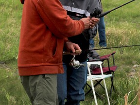 KASSIDY CHRISTENSEN HIGH RIVER TIMES. From left: Sean Phillips shows Steven Makeechak some of his fishing tricks at the special needs fishing derby put on by the High River Fish and Game club held June 2.