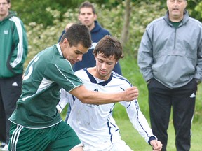 St. Michael Warriors' Lucas Culliton vies for the ball with with Benjamin Kuennen of Holy Cross during OFSAA soccer action at Packham Rd. fields Friday. (SCOTT WISHART, The Beacon Herald)