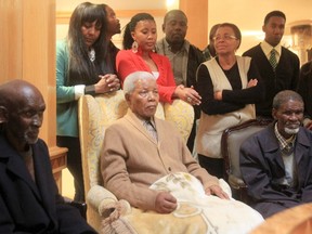 Former South African President Nelson Mandela (C) receives a torch (unseen) marking 100 years since the founding of the African National Congress at Mandela's Qunu home, May 30, 2012.  REUTERS/Lulamile Feni/Daily Dispatch