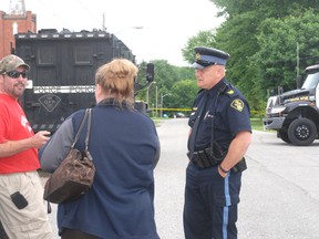 Middlesex OPP discuss a situation with local residents as they man a roadblock on Dundas Street in Newbury Friday where a man barricaded himself inside a house.